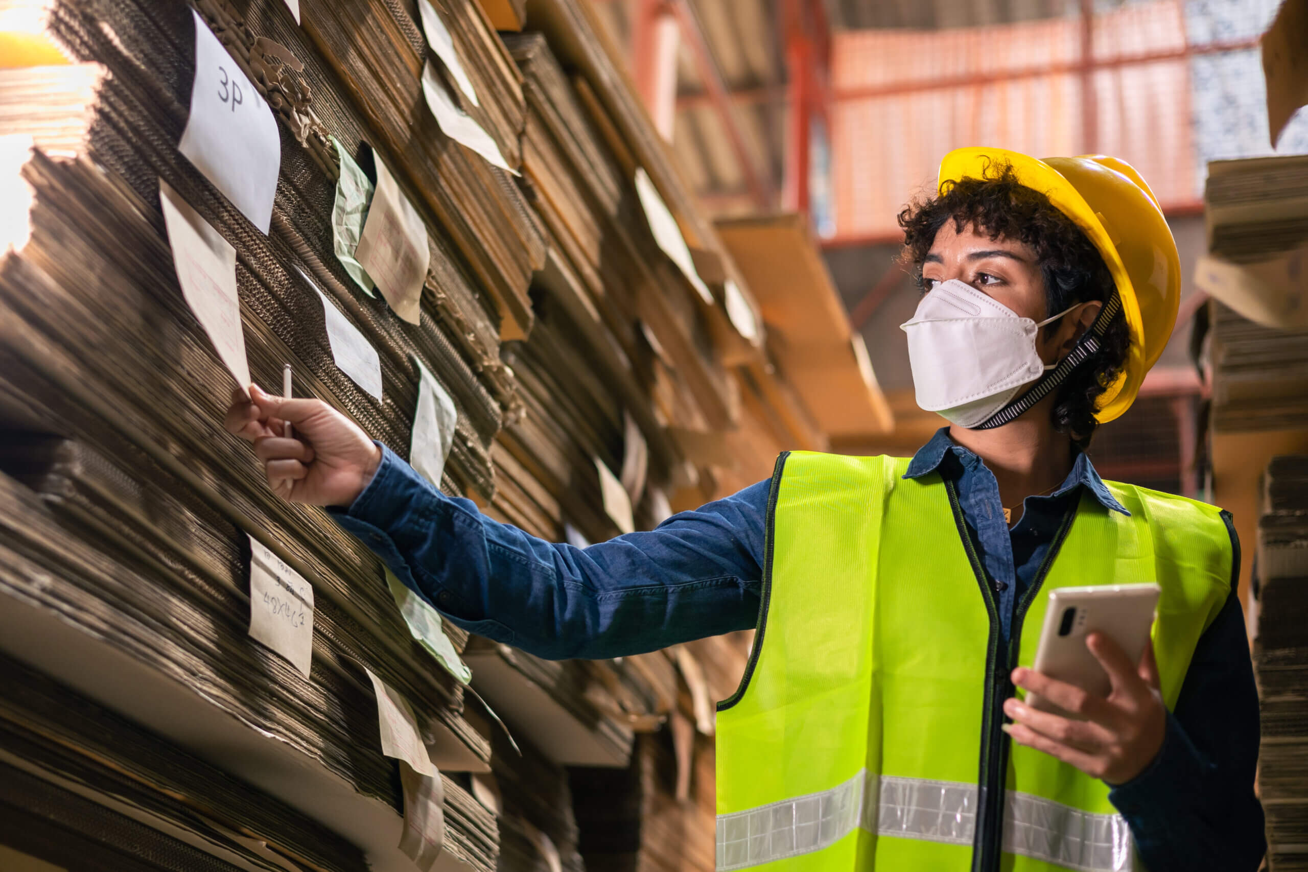 Engineer wearing safety helmet and vest holding clipboard and t